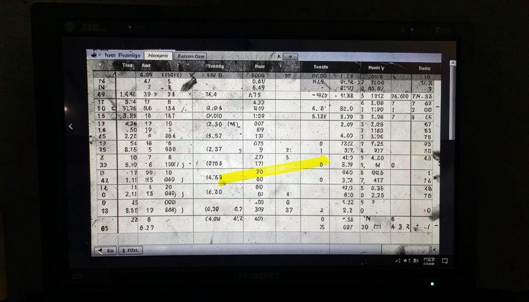 A spreadsheet with tuning data open on a monitor, columns of numbers and parameters, dark screen with light text